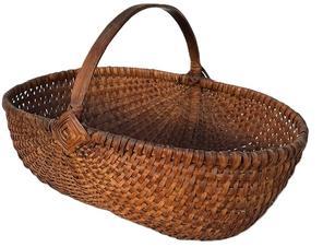 **SOLD** K1844 Oval shaped Melon Basket of ribbed and woven oak splint construction with natural finish boasting the "Eye of the Wind God" on each side of the handle. Tightly woven. Approximate Measurements: 15 &frac14;� long x 10 &frac34;� wide x 10� tall at handle. The sides are 5 &frac14;� tall. 