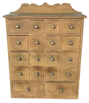 J126 Late 19th century Pennsylvania original Mustard painted apothecary / spice cabinet featuring an unusual 18 drawer layout with brass pulls. The drawer stretchers are mortised into the ends. A decorative cut out backsplash adorns the back while a chamfered edge surrounds the other three sides of the top.  Measurements: 21� wide x 8 &frac12;� deep x 27� tall (center of back). The front measures 24� tall.  