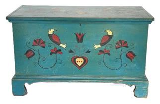 **SOLD** M55 Exceptional early to mid-19th century Pennsylvania Child's Blanket Chest retaining its original blue painted surface adorned with hand painted Pennsylvania Dutch motif decorations including hearts and birds. The wood is pine, six-board dovetailed construction case with applied molding around the lid and an applied bracket base with wonderful cut out feet. Clean, natural patina interior with lidded till. Identified on back (partially illegible) ��..Lancaster Pa�. Measurements: 28 &frac34;� wide x 14 &frac12;� deep x 17 &frac12;� tall.   