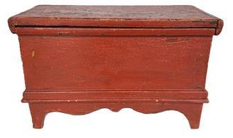 L516 19th century New England miniature blanket chest with old red painted surface featuring tall cut out feet, decorative apron and applied moldings. The wood is white pine with square head nail construction. Natural patina interior. Circa 1860s-1880s. Measurements: 18 &frac34;� wide x 9 &frac12;� deep x 11 &frac34;� tall.   