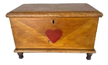 **SOLD** SB24 Exquisite early 19th century miniature Pennsylvania paint decorated blanket chest retaining its original overall mottled and stripe mustard paint decorated surface with a central heart in red paint. Six board, finely dovetailed construction with square head nails securing the bottom. Molded edges surround the top and bottom. Clean, natural patina interior with lidded til inside. The wood is pine with applied turned walnut feet. Circa 1820s. Measurements: 14 &frac12;� wide x 7 &frac14;� deep x 9� tall. 