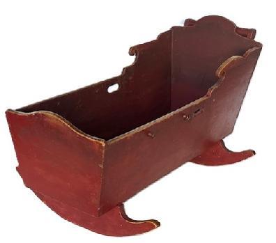 L87 19th century rocking cradle bearing original red painted surface. Beautiful handmade dovetail construction with cut out handles on each side and an applied round handle at the top. The wood is pine. Circa 1840 � 1860s. Overall measurements: 39 &frac12;� long x 23 &frac12;� wide. Cradle box measures 37 &frac34;� long x 15� wide. 