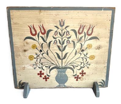 M74 Folk Art hand painted wooden Fireplace Screen depicting a large Urn of Flowers on a white background with a blue painted border and feet. Signed and dated (�91) by the artist in lower right corner. Applied battens on back have kept the board from twisting / warping. Wooden feet at the bottom allow for sturdy display of this great piece of Folk Art!