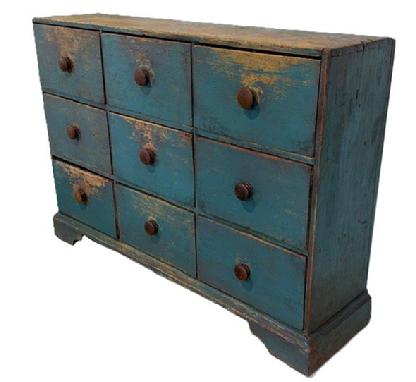 **SOLD** M2 18th century Pennsylvania nine (9) drawer apothecary with applied bracket base bearing old blue painted surface. Dovetailed case and dovetailed drawers. Four of the drawers retain mortised divided interiors. The wood is pine with a combination of �T�, rosehead and square head nail construction. Circa 1790-1810. Base measures: 50 &frac14;� wide x 13� deep. The case is 48 &frac14;� wide x 12 &frac14;� deep. Overall height Is 33 &frac34;� tall. 