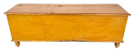 H921 Early 19th century Lancaster County, Pennsylvania mustard painted split lid wood box resting on turned feet. Rounded edges surround top and bottom. Dovetailed case. Divided interior with clean, natural patina. One board construction. The wood is pine. Circa 1820. Measurements: 72 &frac34;� wide x 19� deep x 21 &frac14;� tall. 