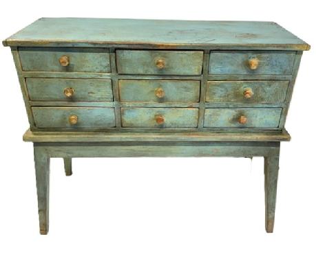 **SOLD** M129 Unique two-piece 19th century Pennsylvania nine drawer apothecary on stand in old blue painted surface with original knobs. Dovetailed drawers with mortised drawer stretchers. A few of the drawers retain divided interiors. The wood is pine with square head nail construction. Measurements: 34 5/8� wide x 13 &frac12;� deep x 29 &frac34;� tall. (Apron to floor measures 14�.)  