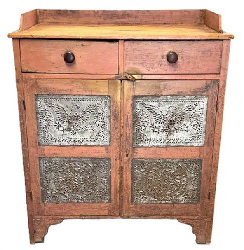 L148 19th century Pennsylvania original salmon painted pie safe featuring 4 Eagle pattern hand-punched tins and 4 circular pattern hand-punched tins with two dovetailed drawers, an applied dovetailed gallery on the top and decorative cutout on front of legs. Natural patina interior with shelving for added storage. Circa 1860s-1870s. Measurements: 39� wide x 18 &frac34;� deep (at gallery) x 43� tall (front) x 45 &frac12;� tall (back). 