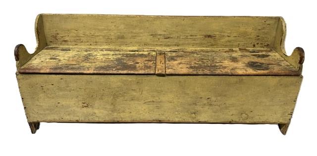M278 Early 19th century Pennsylvania Settle / Wood Box circa 1800-1820 bearing old mustard yellow painted surface with double lift lids, a raised back, lollipop cut out and shaped ends resting on half-moon cut out feet. The wood is pine with �T� nail and square head nail construction. Great wear from years of use. Measurements: 72� wide x 17 &frac34;� deep x 30� tall (back) x 19 &frac34;� tall (front). 