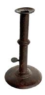 L372H Early 19th century Hog Scraper Wedding ring / band Candlestick. No evidence of ever having a finger curl at the top. Working push-up tab is unmarked.  Sturdy sheet iron construction with metal wedding band. Dark, natural surface. Circa 1800-1820. Measurements: 4" diameter base x ~7 &frac12;� tall. 