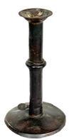 L372F Early 19th century Wedding band hog scraper candle stick with remnants of maker's stamp on the working push-up tab. Sheet iron construction with wedding band. No evidence of ever having a finger curl. Base has break along the edge. Surface patina indicative of age and use. Measurements: 4" diameter base x 7 &frac12;� tall. 