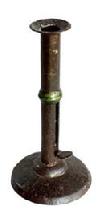 L372E Early 19th century Wedding band hog scraper candle stick with remnants of maker's stamp on the working push-up tab. Sturdy sheet iron construction with brass wedding band. No evidence of ever having a finger curl. Early make-do repair to base. Surface patina indicative of age and use. Measurements: 4" diameter base x 7 5/8" tall.  
